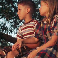 Young Forrest and young Jenny hold hands.