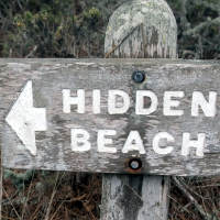 A sign saying 'Hidden Beach'; CC-BY from https://www.flickr.com/photos/carbonnyc/76468122